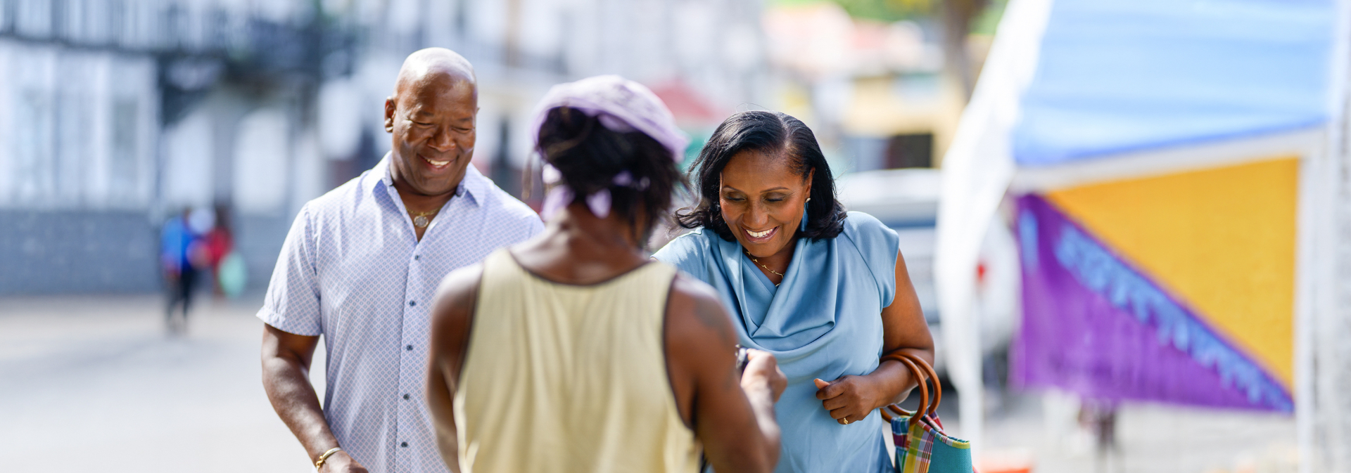Donna Frett-Gregory and Rodney Moorehead greeting a community member at a local market